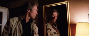 Movie still from “Sudden Impact” (1983), directed by Clint Eastwood – A man looking at himself in the mirror; Medium shot, Low angle