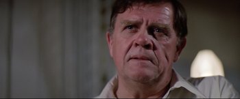 Movie still from “Sudden Impact” (1983), directed by Clint Eastwood – An older man with a serious look on his face; Close Up shot, Low angle