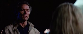 Movie still from “Sudden Impact” (1983), directed by Clint Eastwood – A person looking at a camera; Close Up shot, Over the shoulder angle