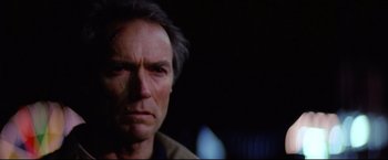 Movie still from “Sudden Impact” (1983), directed by Clint Eastwood – A man's face in a dark room; Close Up shot, Low angle