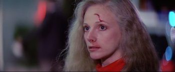 Movie still from “Sudden Impact” (1983), directed by Clint Eastwood – A woman with a red scar on her forehead; Close Up shot, Over the shoulder angle