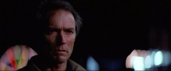 Movie still from “Sudden Impact” (1983), directed by Clint Eastwood – A man's face in a dark room; Close Up shot, Low angle