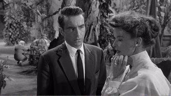 Movie still from “Suddenly, Last Summer” (1959), directed by Joseph L. Mankiewicz – A man and a woman standing next to each other in front of a tree; Close Up shot, Over the shoulder angle