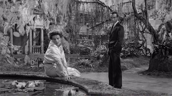 Movie still from “Suddenly, Last Summer” (1959), directed by Joseph L. Mankiewicz – A man and a woman standing next to each other in a garden; Wide shot, High angle