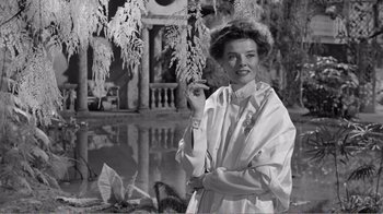 Movie still from “Suddenly, Last Summer” (1959), directed by Joseph L. Mankiewicz – An old photo of a woman in a white dress by a pond; Medium shot, Low angle