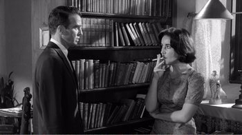 Movie still from “Suddenly, Last Summer” (1959), directed by Joseph L. Mankiewicz – A man and a woman in front of a book shelf; Medium shot, Low angle