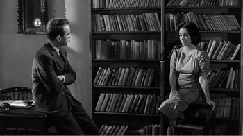 Movie still from “Suddenly, Last Summer” (1959), directed by Joseph L. Mankiewicz – A man and a woman sitting in front of a book shelf; Medium shot, Over the shoulder angle