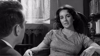 Movie still from “Suddenly, Last Summer” (1959), directed by Joseph L. Mankiewicz – A woman sitting on a couch in a room; Close Up shot, Over the shoulder angle