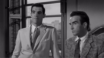 Movie still from “Suddenly, Last Summer” (1959), directed by Joseph L. Mankiewicz – A man in a suit and tie standing next to another man in a suit and tie; Medium shot, Low angle