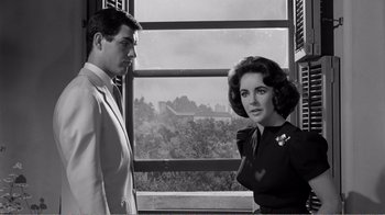 Movie still from “Suddenly, Last Summer” (1959), directed by Joseph L. Mankiewicz – A man and a woman standing in front of a window; Medium shot, Over the shoulder angle