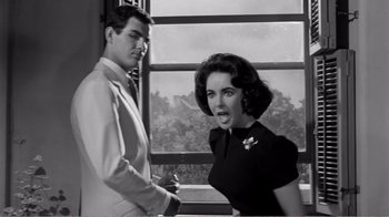 Movie still from “Suddenly, Last Summer” (1959), directed by Joseph L. Mankiewicz – A man and a woman standing next to each other; Medium shot, Low angle