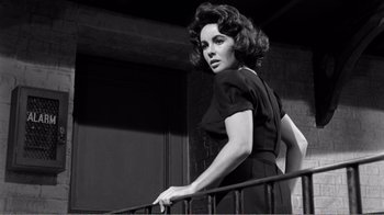 Movie still from “Suddenly, Last Summer” (1959), directed by Joseph L. Mankiewicz – Black and white photograph of a woman leaning on a railing; Medium shot, Low angle