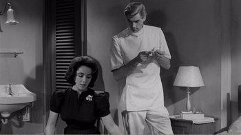 Movie still from “Suddenly, Last Summer” (1959), directed by Joseph L. Mankiewicz – A man and a woman are standing in a room; Medium shot, Low angle