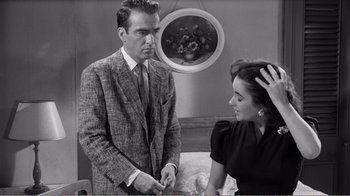 Movie still from “Suddenly, Last Summer” (1959), directed by Joseph L. Mankiewicz – A man and a woman are standing in front of a mirror; Medium shot, Over the shoulder angle