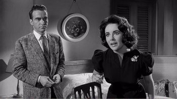 Movie still from “Suddenly, Last Summer” (1959), directed by Joseph L. Mankiewicz – A man and a woman sitting in front of each other in a room; Medium shot, Over the shoulder angle