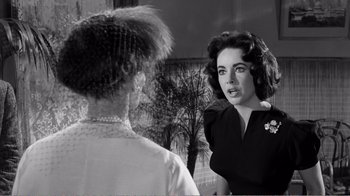 Movie still from “Suddenly, Last Summer” (1959), directed by Joseph L. Mankiewicz – A woman talking to another woman in front of a building; Close Up shot, Over the shoulder angle