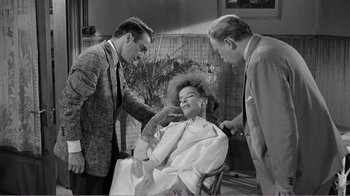 Movie still from “Suddenly, Last Summer” (1959), directed by Joseph L. Mankiewicz – A woman getting her hair combed by two men; Medium shot, Over the shoulder angle