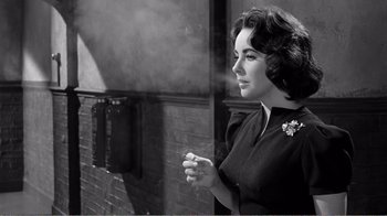 Movie still from “Suddenly, Last Summer” (1959), directed by Joseph L. Mankiewicz – An old black and white photo of a woman smoking a cigarette; Close Up shot, Low angle