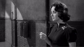 Movie still from “Suddenly, Last Summer” (1959), directed by Joseph L. Mankiewicz – An old photo of a woman holding a cigarette in her hand; Close Up shot, Over the shoulder angle
