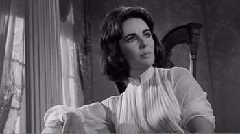 Movie still from “Suddenly, Last Summer” (1959), directed by Joseph L. Mankiewicz – A woman sitting in front of a window in front of a curtain; Close Up shot, Low angle