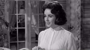 Movie still from “Suddenly, Last Summer” (1959), directed by Joseph L. Mankiewicz – A black - and - white photo of a woman in a white dress; Close Up shot, Over the shoulder angle