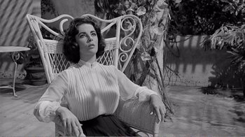 Movie still from “Suddenly, Last Summer” (1959), directed by Joseph L. Mankiewicz – A woman sitting in a chair in front of a tree; Medium shot, Low angle