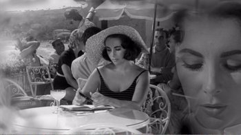 Movie still from “Suddenly, Last Summer” (1959), directed by Joseph L. Mankiewicz – A woman sitting at an outdoor table writing on a piece of paper; Medium shot, High angle