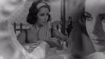 Movie still from “Suddenly, Last Summer” (1959), directed by Joseph L. Mankiewicz – A woman sitting at a table in front of a fence; Close Up shot, Over the shoulder angle