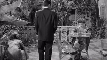 Movie still from “Suddenly, Last Summer” (1959), directed by Joseph L. Mankiewicz – A black and white photo of a man and a woman sitting at a table; Medium shot, High angle
