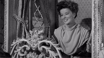 Movie still from “Suddenly, Last Summer” (1959), directed by Joseph L. Mankiewicz – An older woman sitting in a chair next to a statue; Medium shot, Low angle