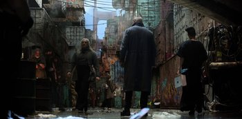 Movie still from “Altered Carbon” (2018), created by Laeta Kalogridis – Two men are walking through a graffiti covered alley; Wide shot, Low angle
