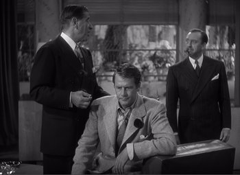 Movie still from “Sullivan's Travels” (1941), directed by Preston Sturges – Three men in suits and ties in a room; Medium shot, Over the shoulder angle