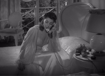 Movie still from “Sullivan's Travels” (1941), directed by Preston Sturges – A black and white photo of a woman talking on a phone; Medium shot, High angle