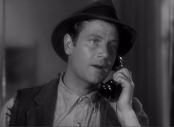 Movie still from “Sullivan's Travels” (1941), directed by Preston Sturges – A man wearing a hat talking on a phone; Close Up shot, High angle