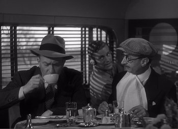 Movie still from “Sullivan's Travels” (1941), directed by Preston Sturges – A group of men sitting at a table drinking coffee; Medium shot, Over the shoulder angle
