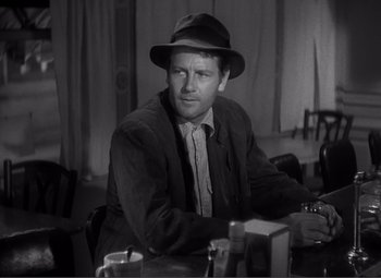 Movie still from “Sullivan's Travels” (1941), directed by Preston Sturges – A black and white photo of a man wearing a hat; Medium shot, Over the shoulder angle