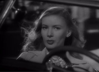 Movie still from “Sullivan's Travels” (1941), directed by Preston Sturges – A black - and - white photo of a woman in a car; Close Up shot, Over the shoulder angle
