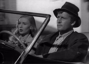 Movie still from “Sullivan's Travels” (1941), directed by Preston Sturges – A man and a woman driving a car in a black and white photo; Close Up shot, Low angle