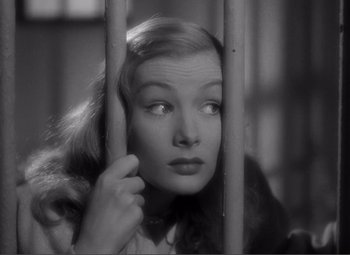 Movie still from “Sullivan's Travels” (1941), directed by Preston Sturges – A black - and - white photo of a woman looking through bars; Close Up shot, Low angle