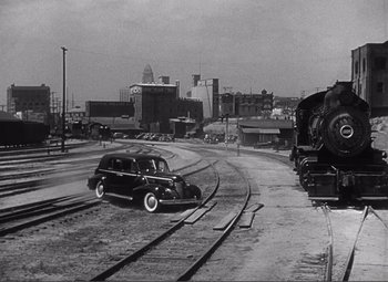 Movie still from “Sullivan's Travels” (1941), directed by Preston Sturges – An old black and white photo of a car on the tracks; Extreme Wide shot, Low angle