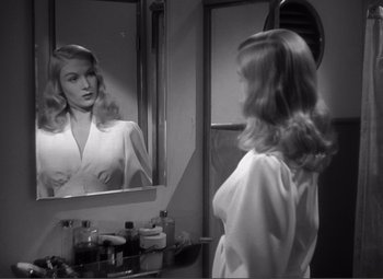 Movie still from “Sullivan's Travels” (1941), directed by Preston Sturges – A black and white photo of a woman looking in the mirror; Close Up shot, Over the shoulder angle