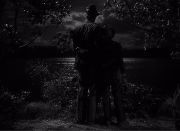Movie still from “Sullivan's Travels” (1941), directed by Preston Sturges – A man and two children sitting on the ground; Wide shot, Low angle