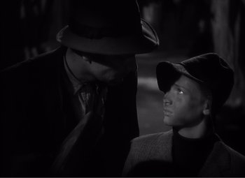 Movie still from “Sullivan's Travels” (1941), directed by Preston Sturges – A man and a boy wearing hats and ties; Close Up shot, High angle