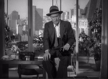 Movie still from “Sullivan's Travels” (1941), directed by Preston Sturges – A black and white photo of a man in a suit and hat; Medium shot, Low angle