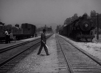 Movie still from “Sullivan's Travels” (1941), directed by Preston Sturges – A man is walking on the train tracks; Extreme Wide shot, High angle