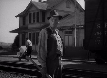 Movie still from “Sullivan's Travels” (1941), directed by Preston Sturges – An older man holding a baseball bat on a train track; Medium shot, Low angle