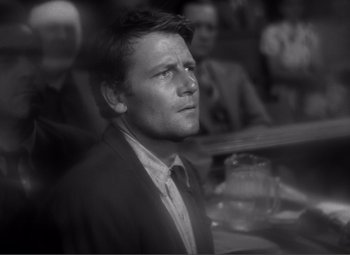 Movie still from “Sullivan's Travels” (1941), directed by Preston Sturges – Black and white photograph of a man in a suit; Close Up shot, Over the shoulder angle