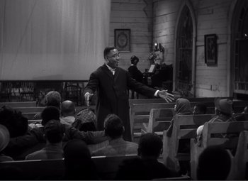 Movie still from “Sullivan's Travels” (1941), directed by Preston Sturges – A man in a suit is shaking hands with a man in a suit; Medium shot, High angle