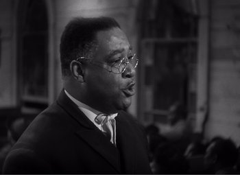 Movie still from “Sullivan's Travels” (1941), directed by Preston Sturges – A black and white photo of a man in a suit; Close Up shot, Low angle