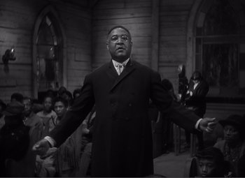 Movie still from “Sullivan's Travels” (1941), directed by Preston Sturges – A man standing in front of a group of people; Medium shot, Low angle